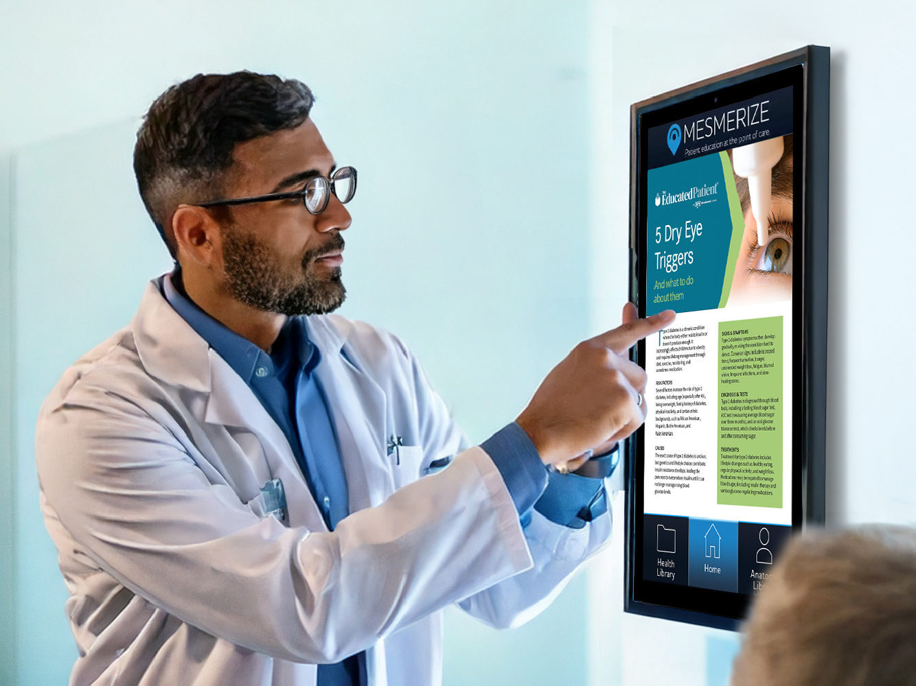 Doctor pointing to information displayed on digital screen for patient to read.